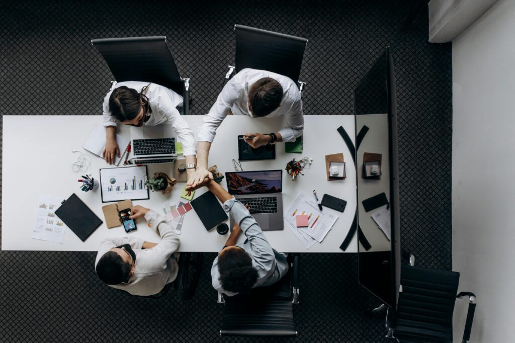 High angle view of colleagues collaborating around a conference table in a modern office setting.